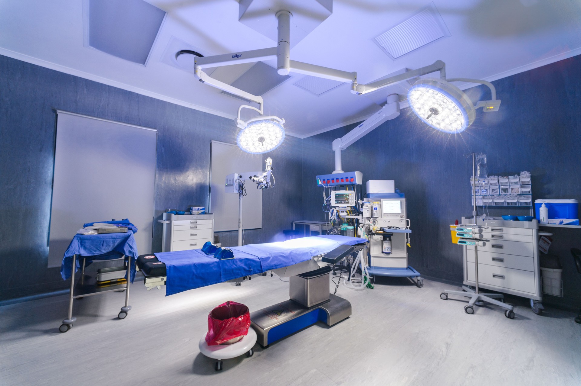 Empty darker modern operation surgery room theatre with operation bed lights monitor and technology