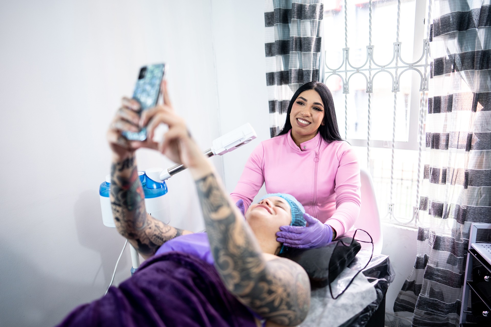 Young woman taking a selfie with her aesthetician/dermatologist at medical clinic